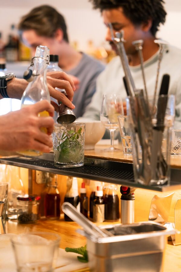 Cocktailzubereitung mit Flasche und Barlöffel im Detail